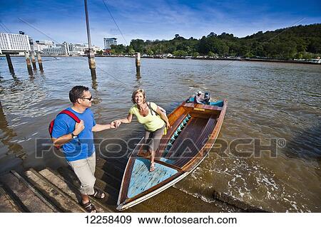 Stock Photo - A couple taking a river boat ride; Bandar Seri Begawan, Brunei. Fotosearch