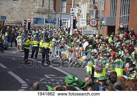 Stock Image - A Crowd And Police On The Street At The Saint Patrick's Day Parade; Dublin Ireland. Fotosearch
