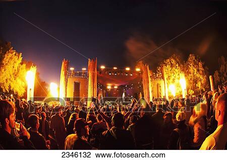 Stock Image - A Crowd During An Outdoor Music Event With Fire Being Shot Up From Both Sides Of The Stage; California, United States Of America. Fotosearch