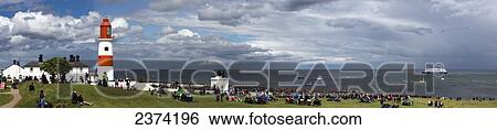 A crowd gathered on the grass along the coast with a view of a ship and boats in the water and Souter Lighthouse; Marsden, Tyne and Wear, England View Large Photo Image Stock Photograph - A crowd gathered on the grass along the coast with a view of a ship and boats in the water and Souter Lighthouse; Marsden, Tyne and Wear, England. Fotosearch