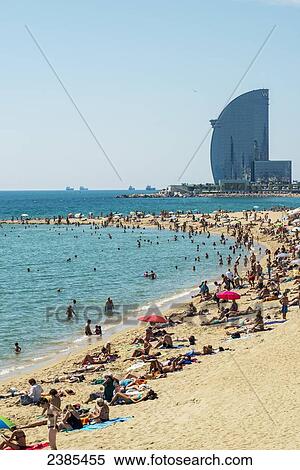Stock Photography - A crowd on Barceloneta beach; Barcelona, Catalonia, Spain. Fotosearch