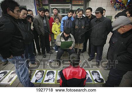 A Crowd Watching A Man Draw A Portrait Of A Boy On The Street, Xian, Xi'an, Capital Of Shaanxi Province, China View Large Photo Image Stock Photo - A Crowd Watching A Man Draw A Portrait Of A Boy On The Street, Xian, Xi'an, Capital Of Shaanxi Province, China. Fotosearch