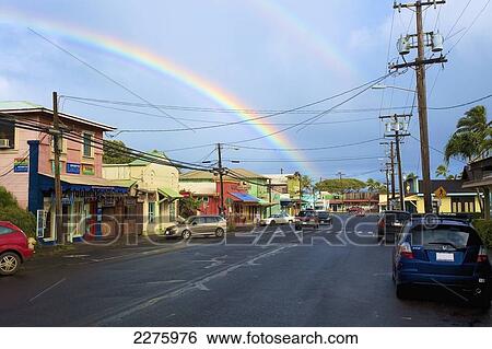 Stock Photograph - A double rainbow over a street and colourful buildings; Hawaii, United States of America. Fotosearch