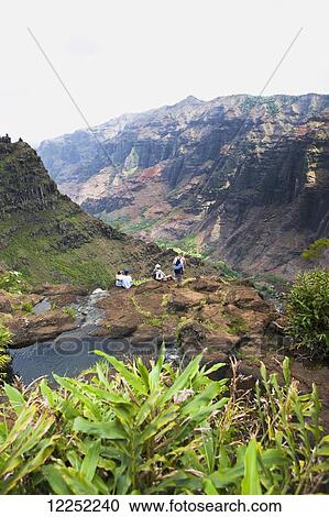 Stock Image - A family overlooks the breathtaking views over Waimea Canyon; Kauai, Hawaii, United States of America. Fotosearch
