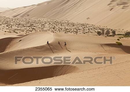 Stock Photography - A family walking in the Empty Quarter; Liwa Oasis, Abu Dhabi, United Arab Emirates. Fotosearch