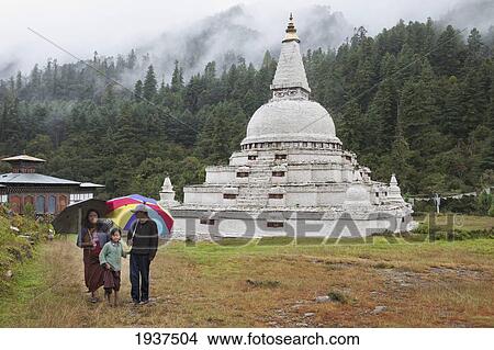 A Family Walks With Umbrellas Away From The Chendebji Chorten; Bhutan View Large Photo Image Picture - A Family Walks With Umbrellas Away From The Chendebji Chorten; Bhutan. Fotosearch