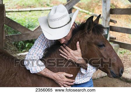 Stock Photography - A Farmer Hugs His Colt; Zacapa, Guatemala. Fotosearch