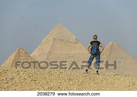 Stock Photo - A Female Tourist Looks Out Toward The Pyramids Of Giza Near Cairo; Giza Egypt. Fotosearch