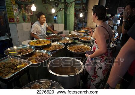 A female tourist ordering a selection of Thai food from a market vendor; Bangkok, Thailand View Large Photo Image Stock Image - A female tourist ordering a selection of Thai food from a market vendor; Bangkok, Thailand. Fotosearch