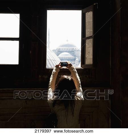 A Female Tourist Takes A Picture Of The Blue Mosque Through A Window At The Hagia Sophia Window; Istanbul Turkey View Large Photo Image Stock Photo - A Female Tourist Takes A Picture Of The Blue Mosque Through A Window At The Hagia Sophia Window; Istanbul Turkey. Fotosearch