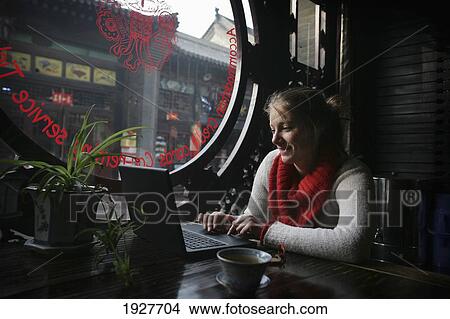 Picture - A Female Tourist Using The Internet On A Laptop In A Guesthouse In Pingyao, A Unesco World Heritage Site, Shanxi Province, China. Fotosearch