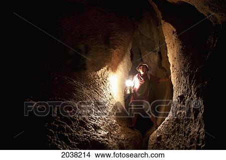 Picture - A Filipino Tour Guide Holds A Lantern Inside Sumaging Cave Or Big Cave Near Sagada; Luzon Philippines. Fotosearch