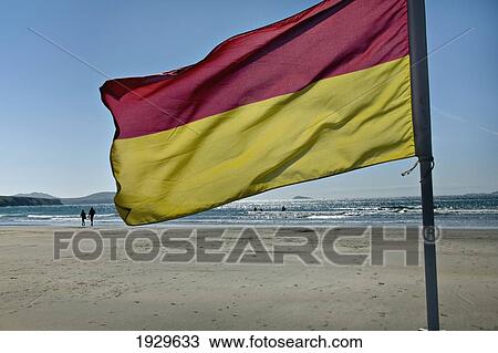 Stock Image - A flag flying on the beach of Whitesands Bay; Pembrokeshire, Wales. Fotosearch