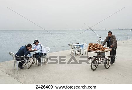 Stock Photo - A food vendor wheels his cart down the promenade; Istanbul, Turkey. Fotosearch
