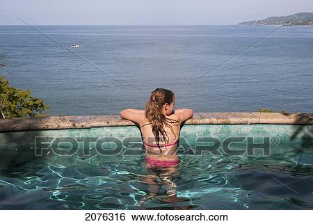 A Girl In A Swimming Pool Looking Out Over The Ocean; Sayulita Mexico View Large Photo Image Stock Photograph - A Girl In A Swimming Pool Looking Out Over The Ocean; Sayulita Mexico. Fotosearch