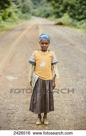 Stock Photograph - A girl on her way to school on a rough road in the Highlands of Ethiopia; Ethiopia. Fotosearch