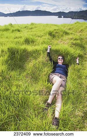 A Girl Relaxes In The Thick Soft Grass On Urupukapuka Island; Bay Of Islands, New Zealand View Large Photo Image Stock Photo - A Girl Relaxes In The Thick Soft Grass On Urupukapuka Island; Bay Of Islands, New Zealand. Fotosearch