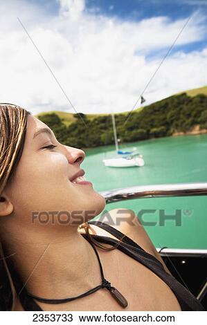Stock Image - A Girl Relaxes On A Boat Cruise From Russell To Paihia; New Zealand. Fotosearch