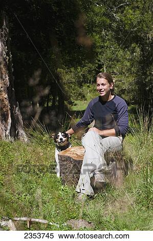 A Girl Sits Relaxing Outside On A Warm Summers Day With Her Dog At Blue Duck Lodge, In Whanganui National Park; Whakahoro, New Zealand View Large Photo Image Stock Photography - A Girl Sits Relaxing Outside On A Warm Summers Day With Her Dog At Blue Duck Lodge, In Whanganui National Park; Whakahoro, New Zealand. Fotosearch