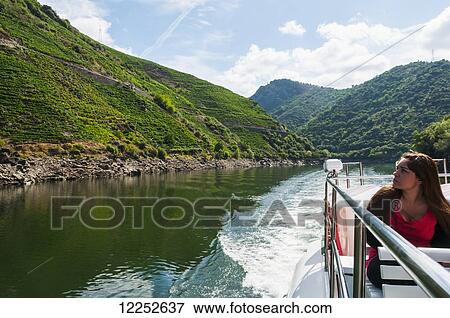 A girl traveling by boat through Sil river, location of the famous Ribiera Sacra vineyards; Galicia, Spain View Large Photo Image Stock Photo - A girl traveling by boat through Sil river, location of the famous Ribiera Sacra vineyards; Galicia, Spain. Fotosearch