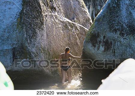 Stock Image - A Girl Wades In The Water At Split Apple Rock In The Abel Tasman National Park; New Zealand. Fotosearch