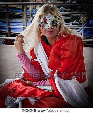 Stock Photo - A girl wearing a colourful eye mask; Venice, Italy. Fotosearch