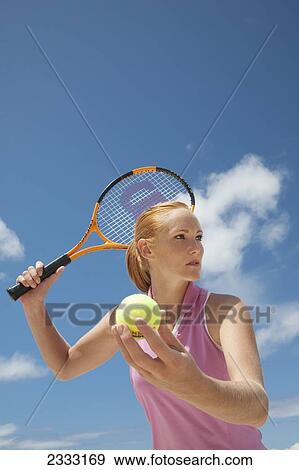 Stock Photo - A girl with a tennis ball and racquet; Oahu, Hawaii, United States of America. Fotosearch