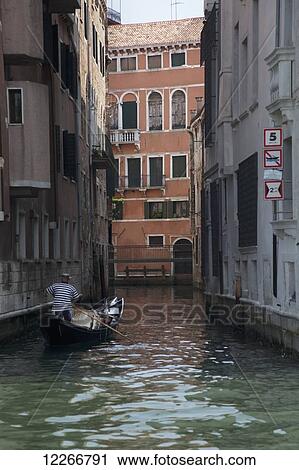 Stock Image - A gondola on a small canal; Venice, Italy. Fotosearch