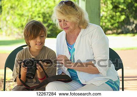 A grandmother and grandson look at pictures on a digital camera screen, National Tropical Botanical Garden; Kauai, Hawaii, United States of America View Large Photo Image Picture - A grandmother and grandson look at pictures on a digital camera screen, National Tropical Botanical Garden; Kauai, Hawaii, United States of America. Fotosearch