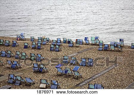 A Gravel Area Along The Shore Of The English Cannel Filled With Deserted Deck Chairs; Devon, England View Large Photo Image Stock Image - A Gravel Area Along The Shore Of The English Cannel Filled With Deserted Deck Chairs; Devon, England. Fotosearch