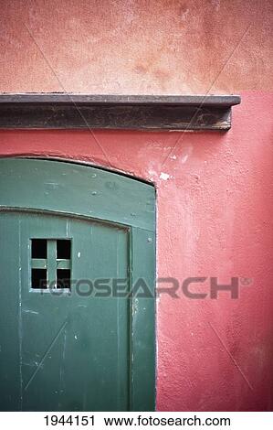 Stock Image - A Green Door On A Red Painted Wall; Genoa Liguria Italy. Fotosearch