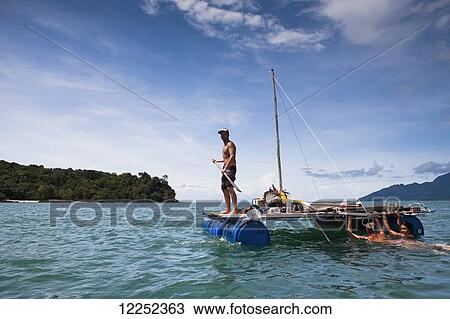 A group of backpackers decide to build their own raft and attempt to raft from Langkawi, Malaysia to Ko Lipe, Thailand; Cenang, Langkawi, Malaysia View Large Photo Image Stock Image - A group of backpackers decide to build their own raft and attempt to raft from Langkawi, Malaysia to Ko Lipe, Thailand; Cenang, Langkawi, Malaysia. Fotosearch