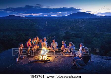 Stock Image - A Group Of People Around A Campfire; Mucombedze Manica Mozambique Africa. Fotosearch