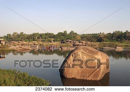 A group of people bathing and cleaning clothes in the river; Hampi, Karnataka, India View Large Photo Image Stock Image - A group of people bathing and cleaning clothes in the river; Hampi, Karnataka, India. Fotosearch