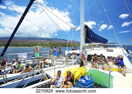 Stock Photo - A group of people enjoying a leisure boat ride off the coast of an hawaiian island; Hawaii, United States of America. Fotosearch