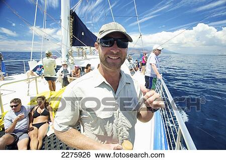 Stock Photograph - A group of people enjoying a leisure boat ride off the coast of an hawaiian island; Hawaii, United States of America. Fotosearch