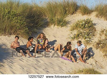 A group of teenagers laying in the sand; Tarifa, Cadiz, Andalusia, Spain View Large Photo Image Stock Photo - A group of teenagers laying in the sand; Tarifa, Cadiz, Andalusia, Spain. Fotosearch