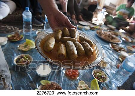 A group of tourists having a traditional lunch with a local family near Al Ayoun trail; Jordan View Large Photo Image Stock Image - A group of tourists having a traditional lunch with a local family near Al Ayoun trail; Jordan. Fotosearch