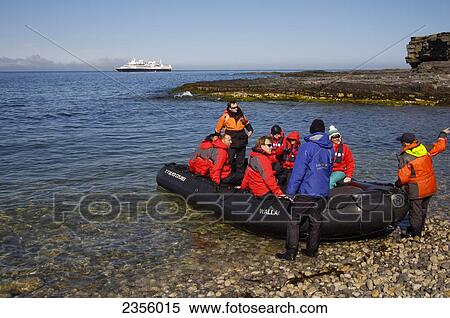 Stock Photography - A group of tourists in an inflatable raft; Svalbard, Norway. Fotosearch