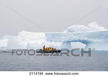 A Group Of Tourists In Yellow Jackets In A Zodiac Travelling By Icebergs; Antarctica View Large Photo Image Picture - A Group Of Tourists In Yellow Jackets In A Zodiac Travelling By Icebergs; Antarctica. Fotosearch