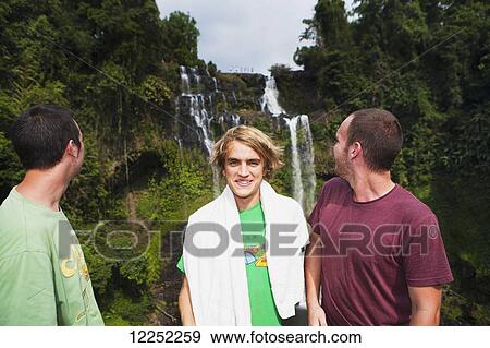 A group of travelers gather to play in the Tad Yuang Waterfall on the Bolaven Plateau; Laos View Large Photo Image Stock Photo - A group of travelers gather to play in the Tad Yuang Waterfall on the Bolaven Plateau; Laos. Fotosearch