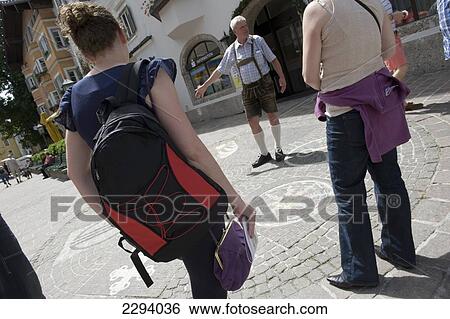 Stock Photograph - A guided walking tour of Kitzbuehel with the guide wearing lederhosen. Tyrol. Austria.. Fotosearch