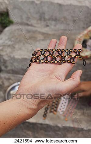 A hand holding a beaded bracelet; Goreme, Cappadocia, Turkey View Large Photo Image Picture - A hand holding a beaded bracelet; Goreme, Cappadocia, Turkey. Fotosearch