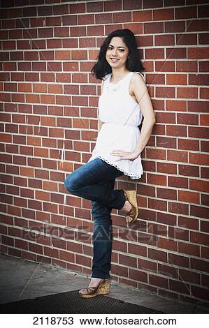 Stock Image - A High School Girl Leans On Wall At The Balboa Fun Zone; Newport Beach California Usa. Fotosearch