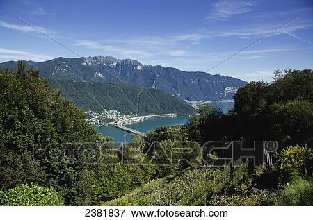 A highway crossing an alpine lake in the swiss alps; Lugano, Ticino, Switzerland View Large Photo Image Stock Photo - A highway crossing an alpine lake in the swiss alps; Lugano, Ticino, Switzerland. Fotosearch