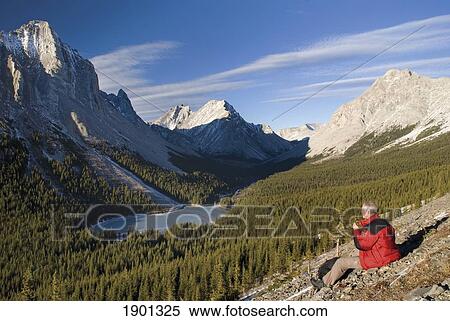 A Hiker Admiring The View Over Frozen Elbow Lake; Kananaskis, Alberta, Canada View Large Photo Image Stock Photography - A Hiker Admiring The View Over Frozen Elbow Lake; Kananaskis, Alberta, Canada. Fotosearch