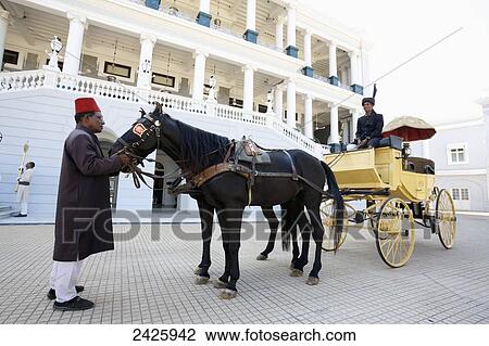 Stock Image - A horse and carriage outside Falaknuma Palace; Hyderabad, Andhra Pradesh, India. Fotosearch