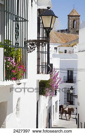 A horse and rider on a narrow street between whitewashed buildings; Vejer de la Frontera, Andalusia, Spain View Large Photo Image Stock Photo - A horse and rider on a narrow street between whitewashed buildings; Vejer de la Frontera, Andalusia, Spain. Fotosearch