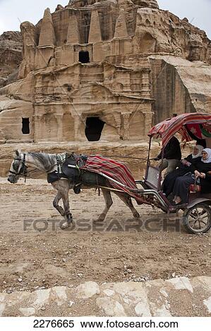 Stock Photography - A horse pulling a carriage of tourists at the UNESCO World Heritage site of Petra, one of the new Seven Wonders of the World; Jordan. Fotosearch