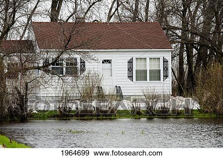 Stock Photo - A House Along The Assiniboine River With A Very High Water Level After Flooding; St. Francois Xavier Manitoba Canada. Fotosearch